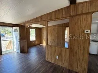 a view of a hallway with wooden floor and windows