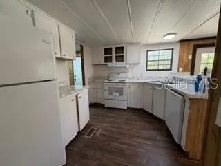 a kitchen with white cabinets and sink