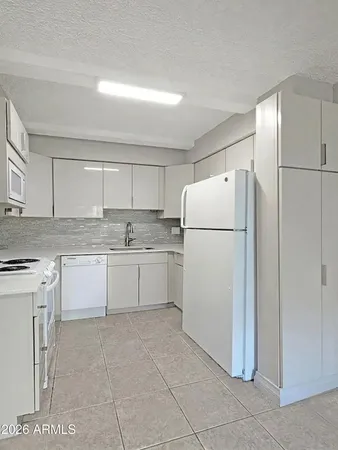 a white refrigerator freezer and a cabinets in it