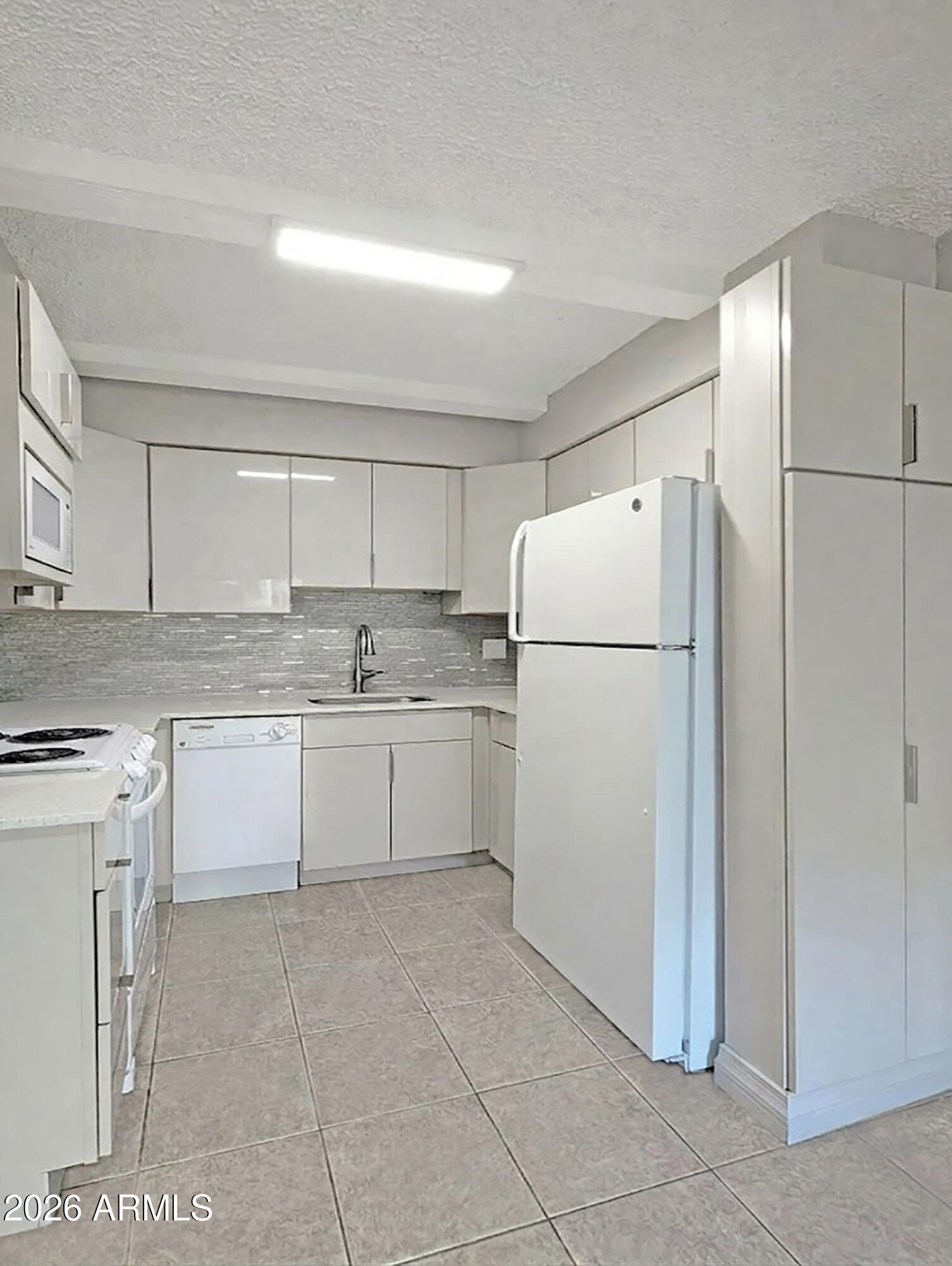 1018 East Osborn Road, Unit A Phoenix, AZ 85014 - Photo 2 of 18 a white refrigerator freezer and a cabinets in it
