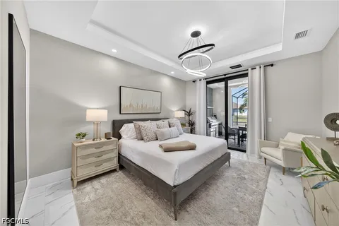 a bedroom with a large bed and a chandelier