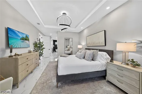 a bedroom with a large bed and a flat tv screen on dresser