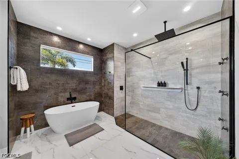 a bathroom with a white tub shower and sink