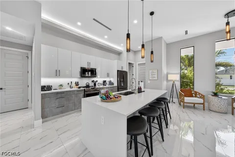 a kitchen with stainless steel appliances kitchen island granite countertop a sink a stove a dining table and chairs