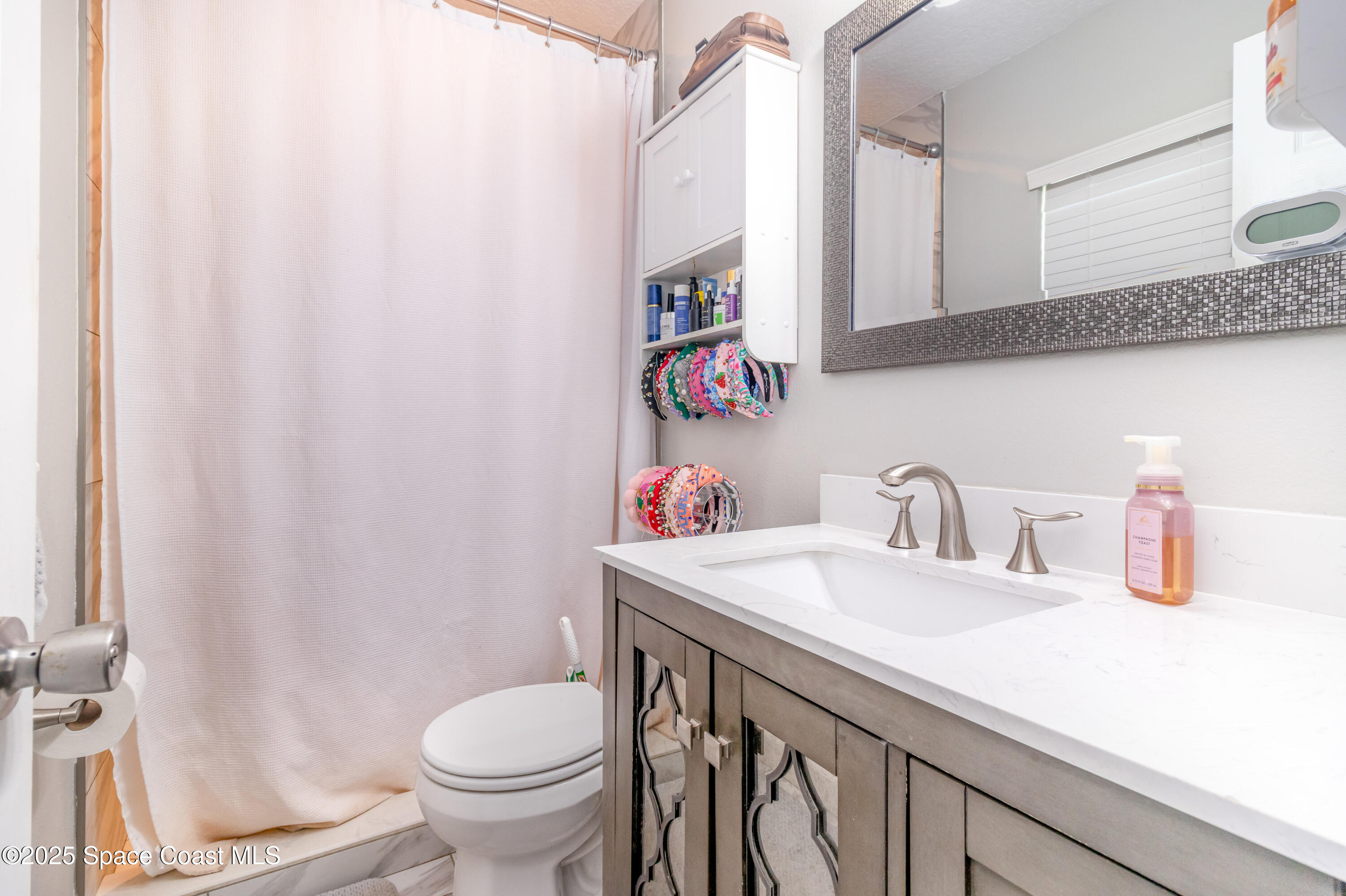 964 Bucknell Place Rockledge, FL 32955 - Photo 14 of 30 a bathroom with a sink a toilet and a mirror