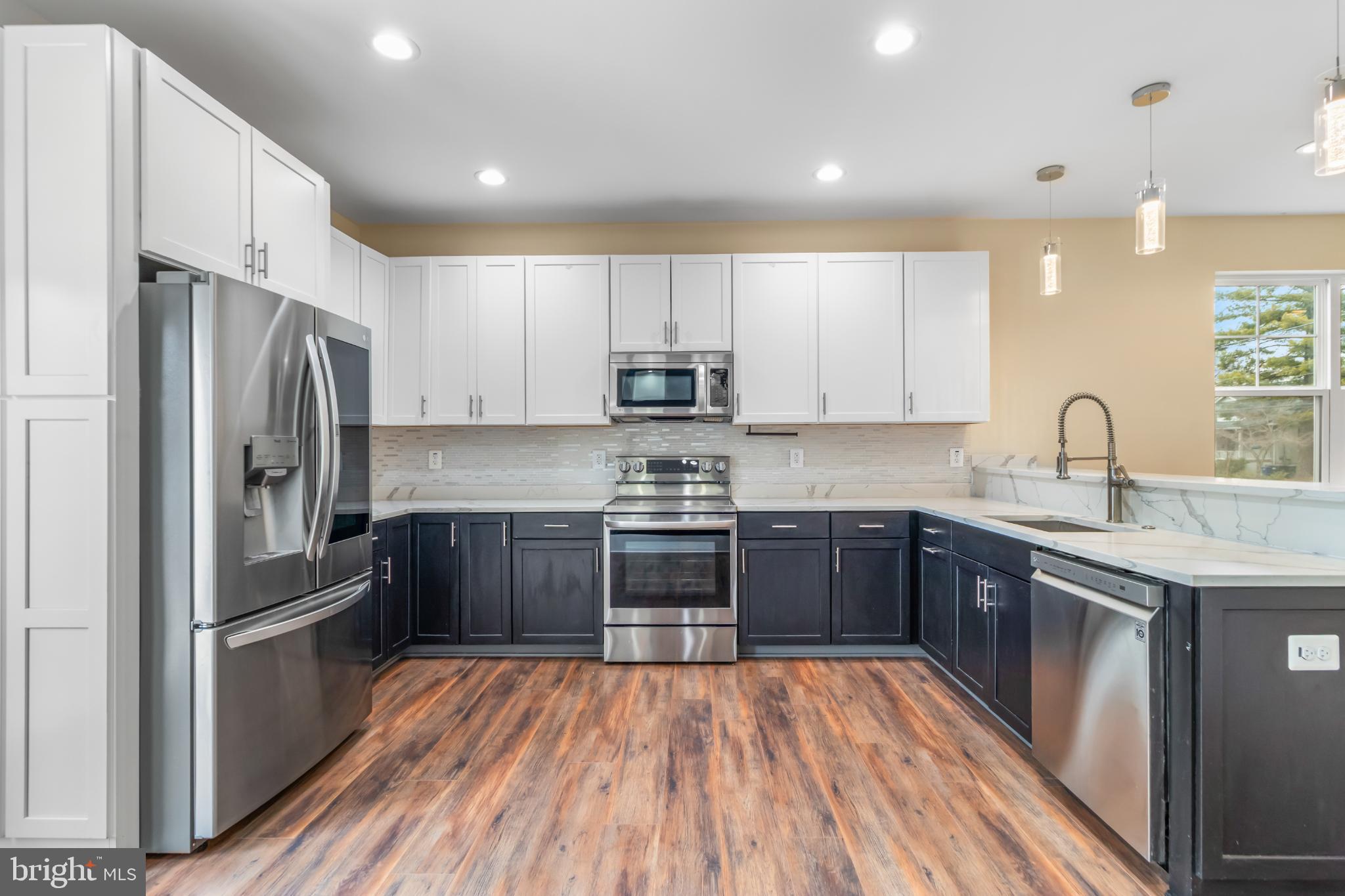 2405 Naylor Road Southeast Washington, DC 20020 - Photo 14 of 23 a kitchen with stainless steel appliances wooden floors a stove and a refrigerator