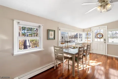 a dining room with wooden floor and a window