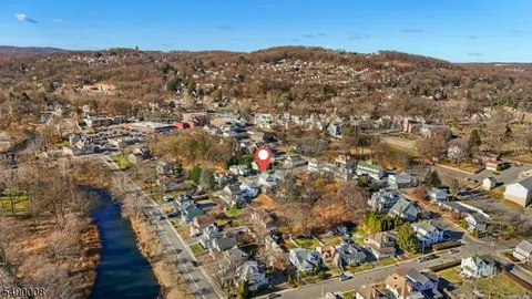 an aerial view of residential houses with outdoor space and trees