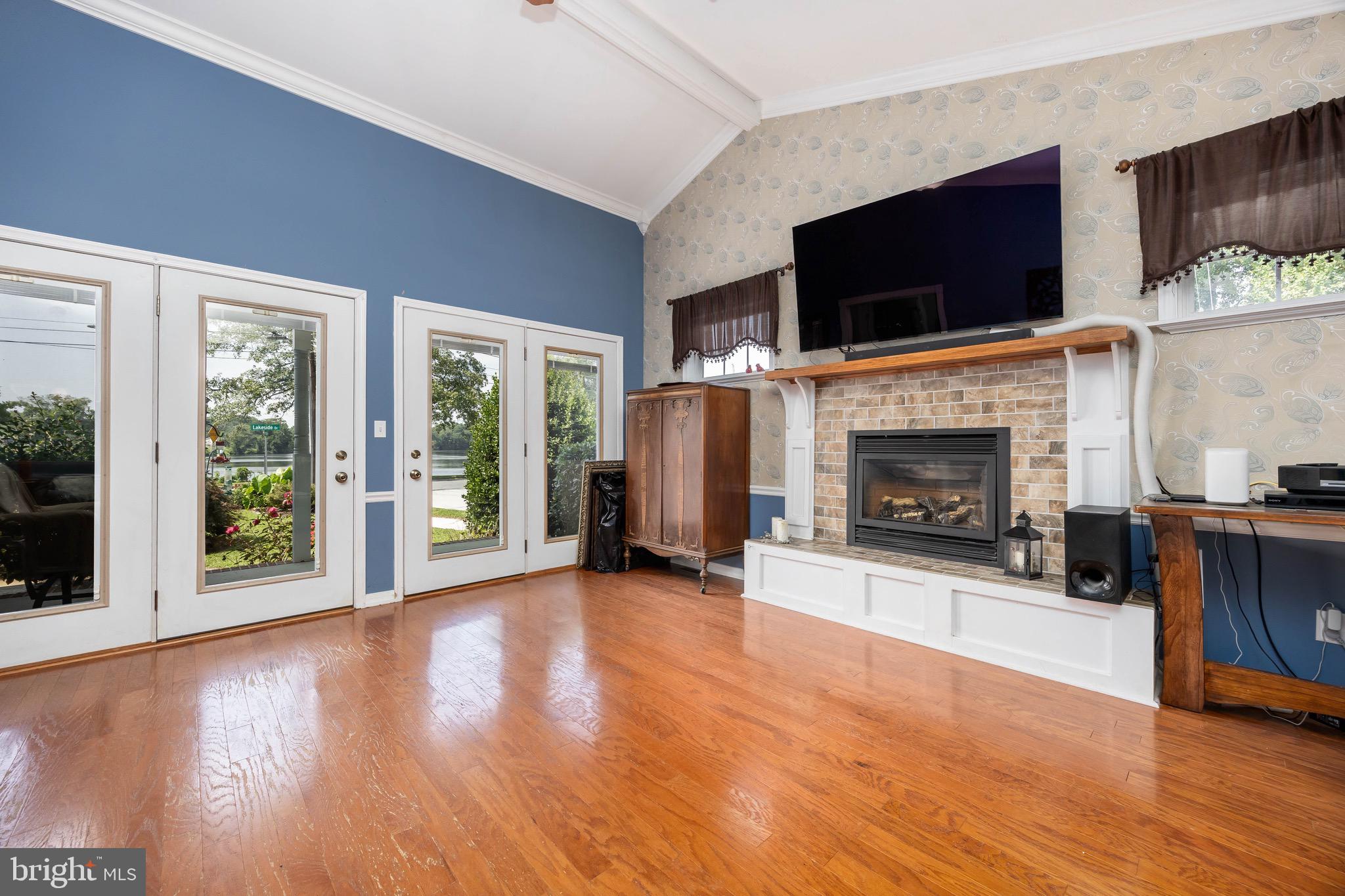 613 Lakeside Drive Salisbury, MD 21801 - Photo 7 of 50 a view of an empty room with furniture a fireplace and wooden floor