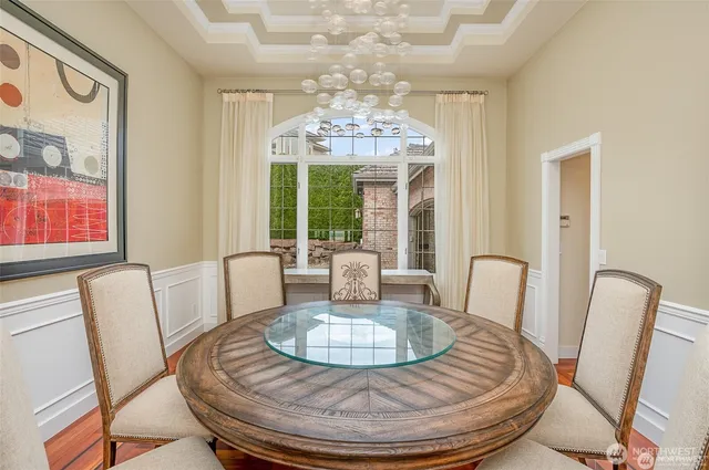a view of a dining room with furniture a chandelier and wooden floor