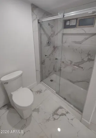 a bathroom with a toilet and a shower