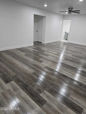 an empty room with wooden floor and windows