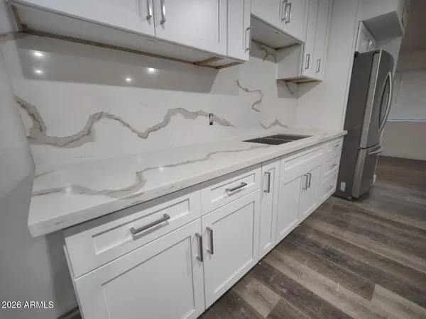 a kitchen with stainless steel appliances white cabinets and wooden floor