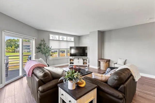 a living room with furniture a flat screen tv and a large window