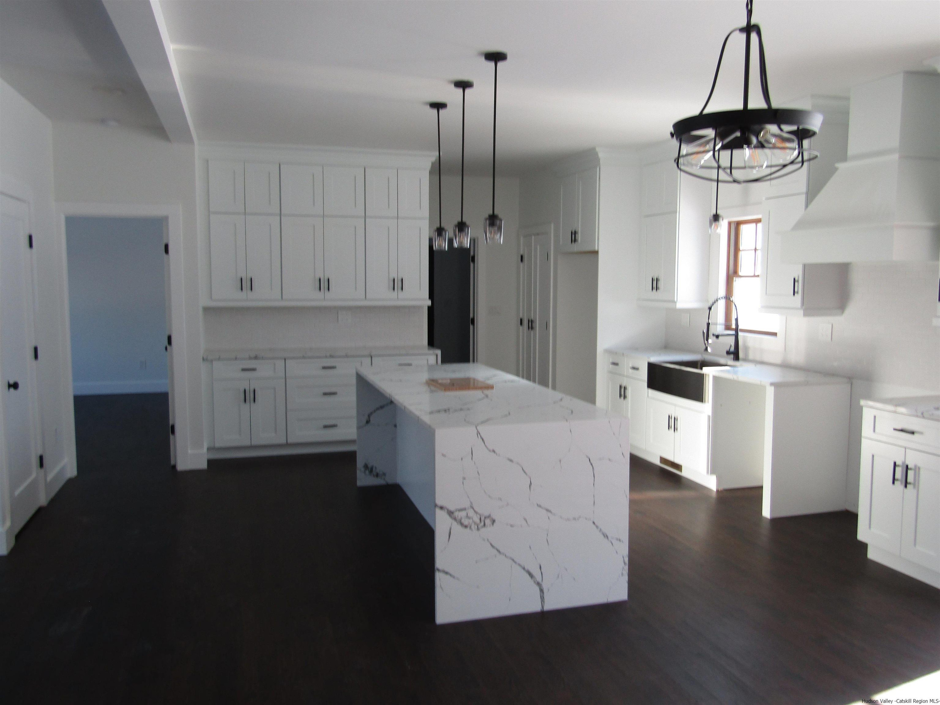 51 Duck Pond Road Stone Ridge, NY 12484 - Photo 9 of 31 a kitchen with a refrigerator a sink dishwasher a stove and a dining table with wooden floor