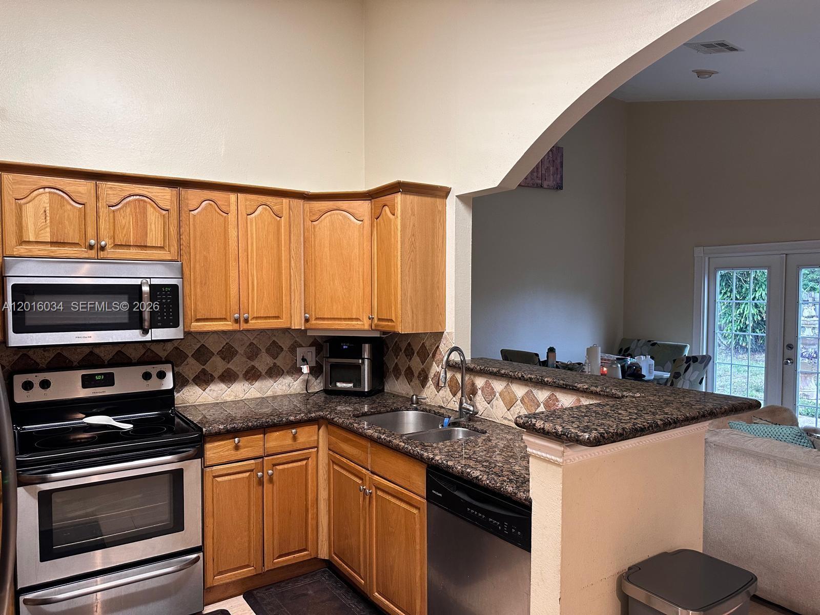11143 Model Circle East Boca Raton, FL 33428 - Photo 7 of 15 a kitchen with stainless steel appliances granite countertop a sink stove and microwave