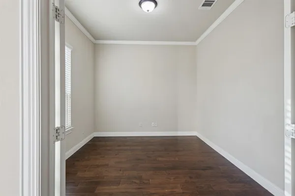 a view of an empty room with wooden floor
