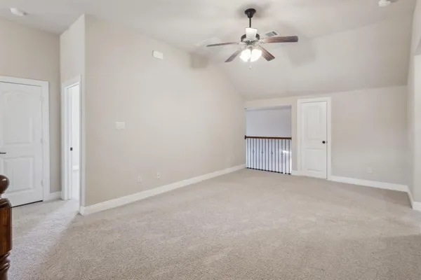an empty room with chandelier fan and ceiling fan