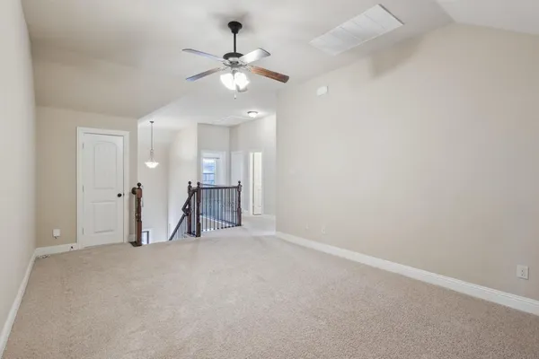 an empty room with a ceiling fan and bathroom view
