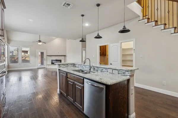 a kitchen with stainless steel appliances granite countertop a stove and a wooden floors