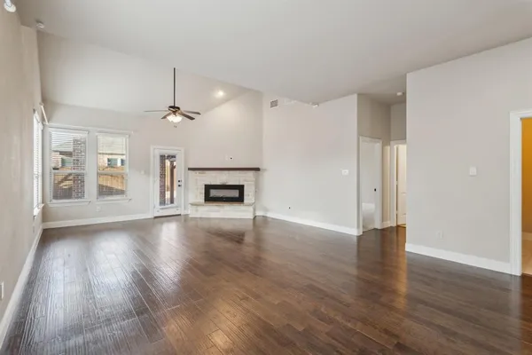 a view of empty room with wooden floor