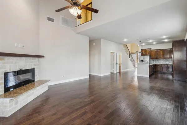 a view of an empty room with a fireplace and window