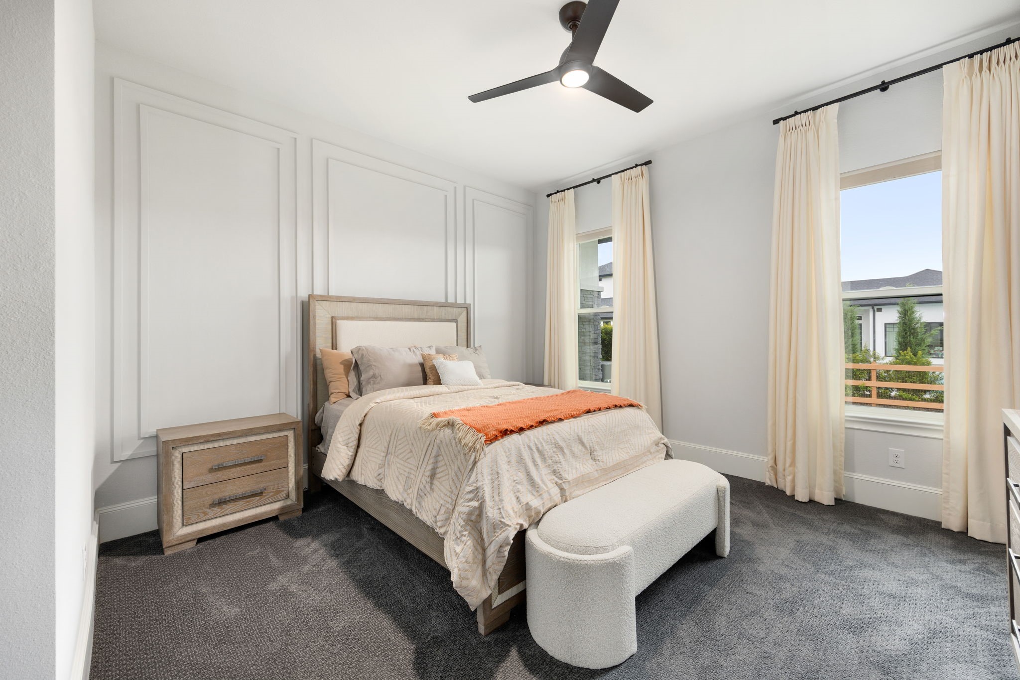 29419 Cir S Rnch Trail Fulshear, TX 77406 - Photo 22 of 45 This comfortable secondary bedroom includes custom geometric wall molding details, plush carpet flooring, a central ceiling fan, and tall multi-pane windows.