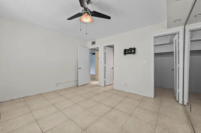 an empty room with chandelier fan