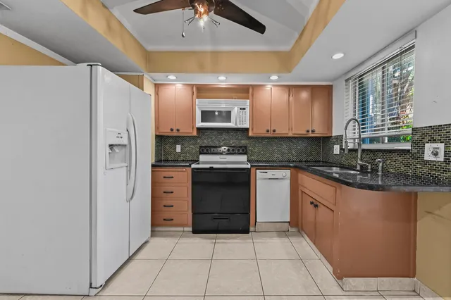 a kitchen with stainless steel appliances granite countertop a refrigerator and a stove