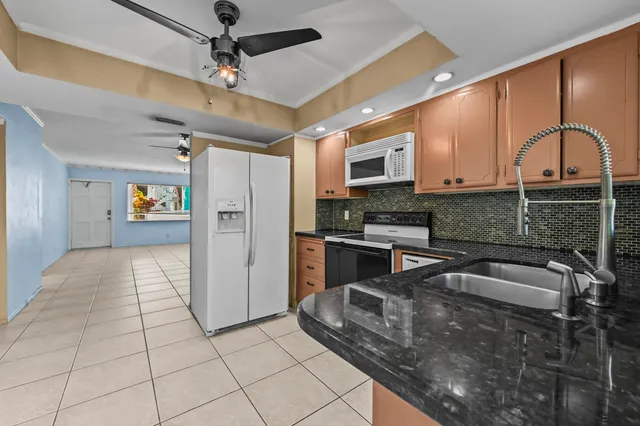 a kitchen with stainless steel appliances granite countertop a sink a stove and cabinets