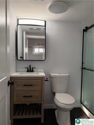 a bathroom with a toilet a sink and mirror