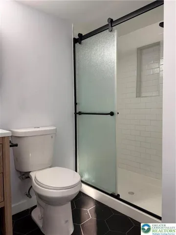 a bathroom with a toilet and a shower