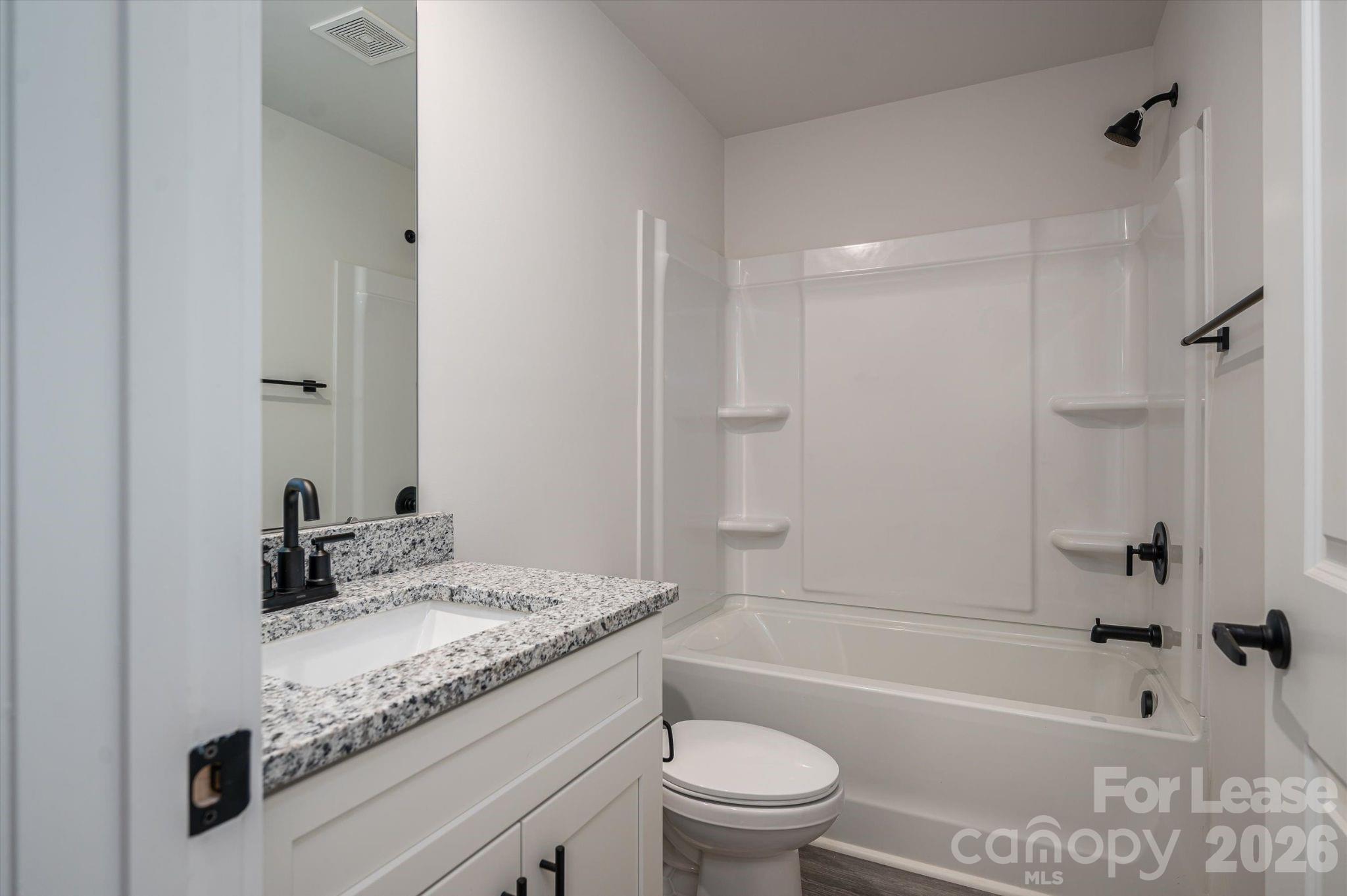 1331 33rd Street Southeast Conover, NC 28613 - Photo 13 of 15 a bathroom with a granite countertop toilet a sink and a bathtub