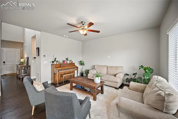 a living room with furniture a chandelier and a potted plant