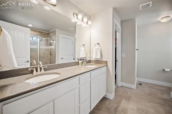 a bathroom with a double vanity sink mirror and shower