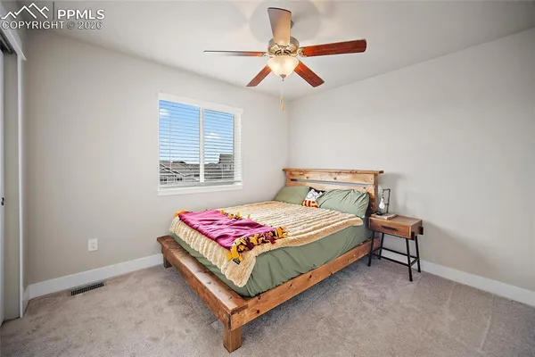 a bedroom with a bed and a chandelier fan