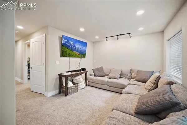 a living room with furniture a coffee table and a flat screen tv