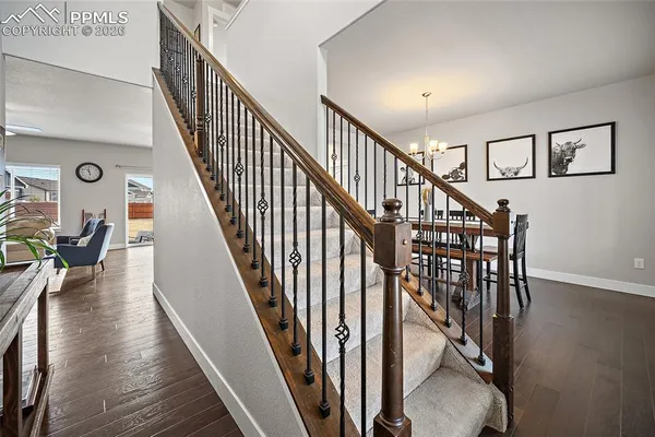 a view of staircase with lots of frames on wall and wooden floor