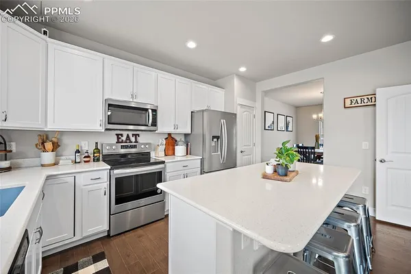 a kitchen with a refrigerator and a stove top oven