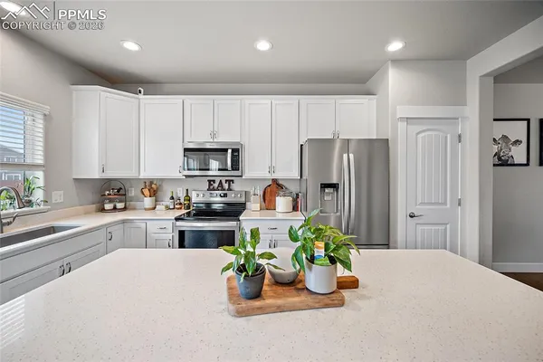a kitchen with white cabinets and stainless steel appliances