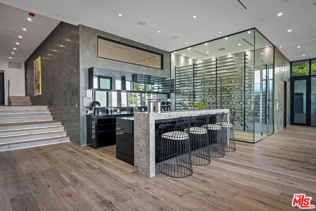 2304 Donella Circle Los Angeles, CA 90077 - Photo 11 of 35 a kitchen with stainless steel appliances kitchen island granite countertop a refrigerator a stove a sink and a dining table with wooden floor