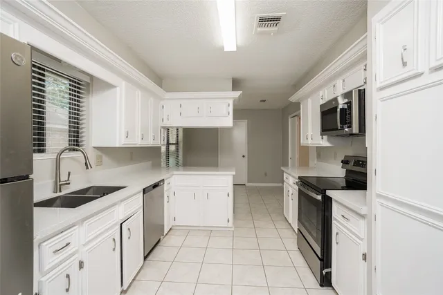 a kitchen with a sink stove top oven and cabinets