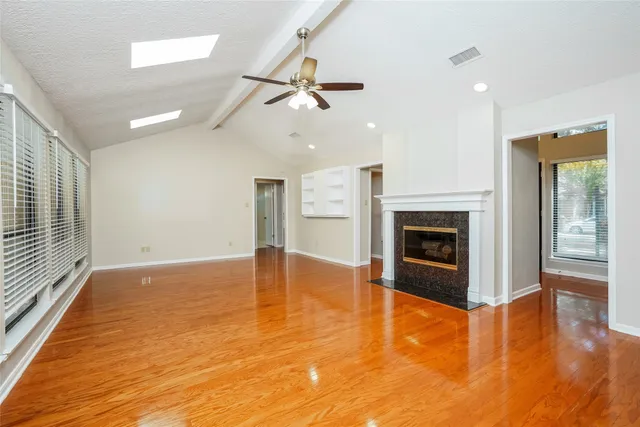 a view of empty room with wooden floor and fireplace