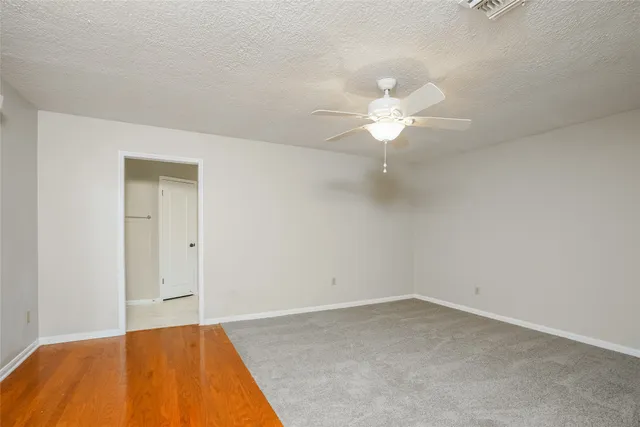 a view of a room with a ceiling fan and a window