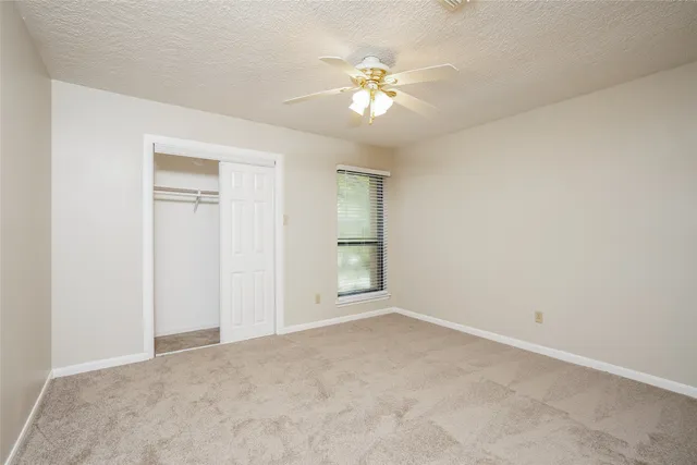 a view of an empty room with a chandelier fan
