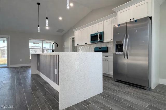 a kitchen with stainless steel appliances a refrigerator and a stove top oven