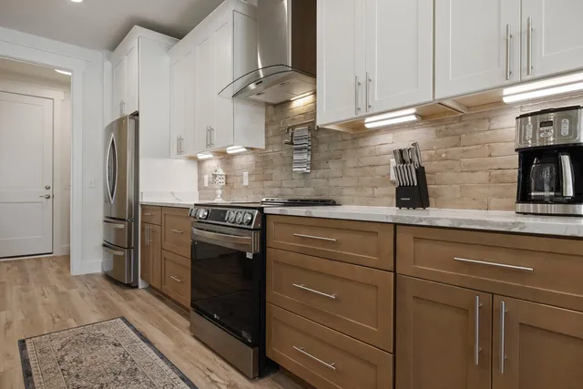 a kitchen with stainless steel appliances granite countertop a sink a stove and refrigerator