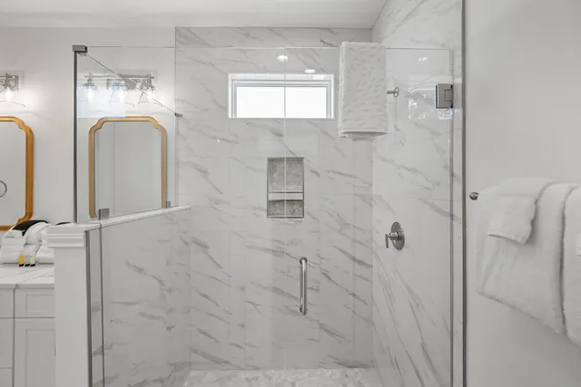 a bathroom with a double vanity sink mirror and shower