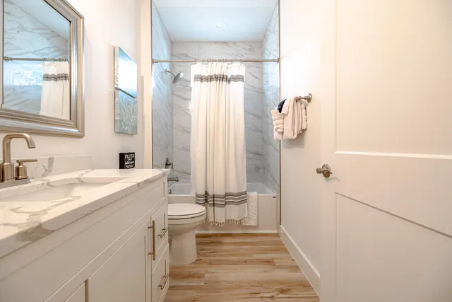 a bathroom with a sink a toilet and shower