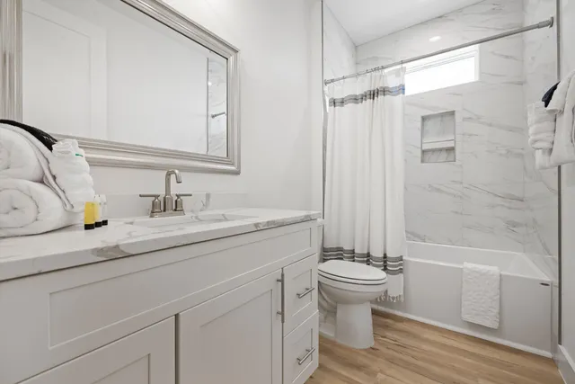 a bathroom with a sink a toilet and shower